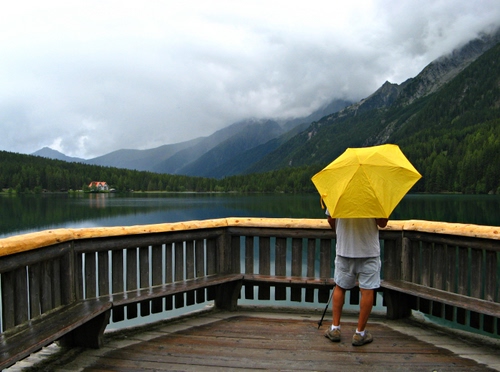 Immagine con lago, ombrello, giallo, montagna, montagne, nuvole, ringhiera
