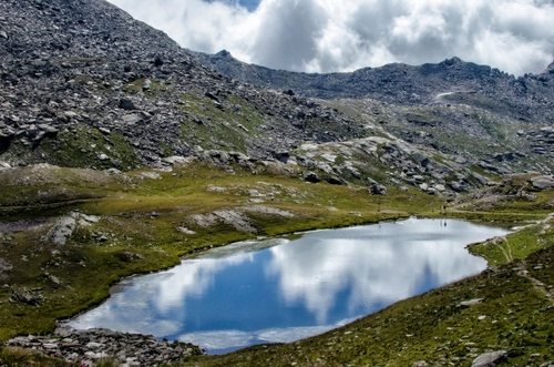 Immagine con lago, nuvole, riflesso, montagna, acqua, montagne, sassi, rocce, cielo