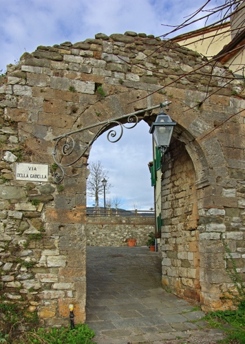 Immagine con arco, lampione, porta, pietra, via, cielo, mattoni, albero