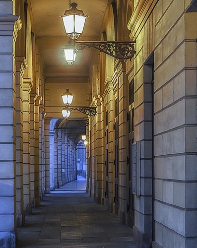 Immagine con lampioni, portico, prospettiva, colonne, luci, portici, sera, corridoio, pilastri, giallo, porte, strada, archi, profondità, luce