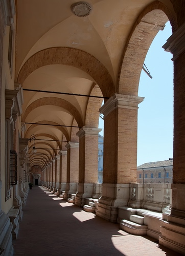 Immagine con colonne, archi, portico, porticato, cielo, scalini, ombra, gradini, pilastri, finestre, prospettiva, ombre, azzurro, scorcio