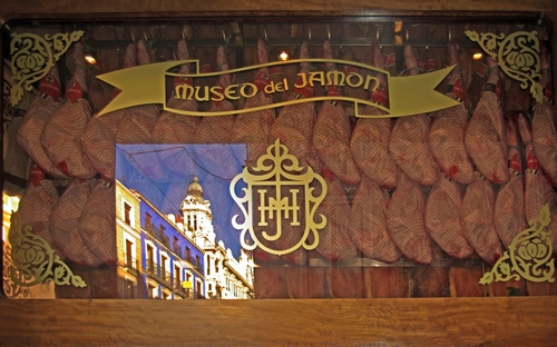 Immagine con vetrina, prosciutti, stemma, museo, riflesso, esposizione, cibo, scritta, prosciutto