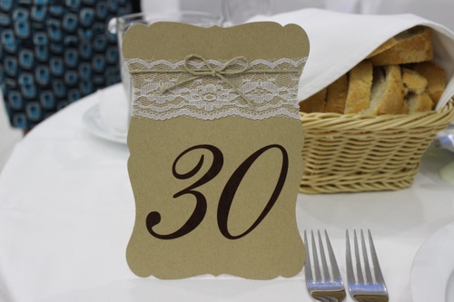 Immagine con forchette, pane, numero, cestino, trenta, posate, tavola, zero, tre, pizzo, tavolo, ricamo, tovaglia, segnaposto, fette, fiocco