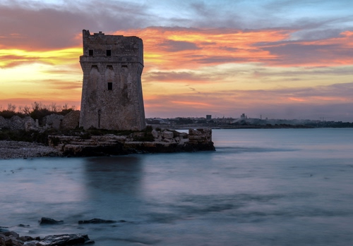 Immagine con torre, tramonto, mare, acqua, nuvole, cielo