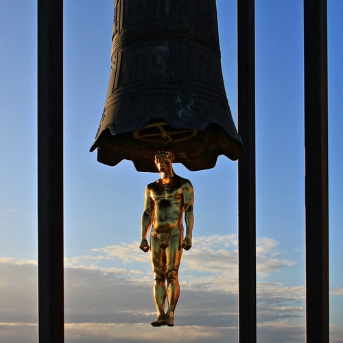 Immagine con campana, statua, cielo, oro, batacchio, uomo, nuvole, bronzo, monumento