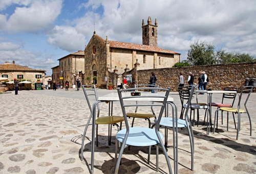 Immagine con chiesa, piazza, sedie, tavoli, tavolini, persone, nuvole, campanile