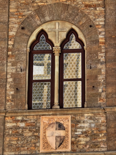 Immagine con croce, finestra, bifora, stemma, colonna, vetri, finestre, bifore, scudo
