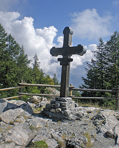 Immagine con croce, nuvole, alberi, montagna, pietre, sassi, cielo, staccionata, roccia