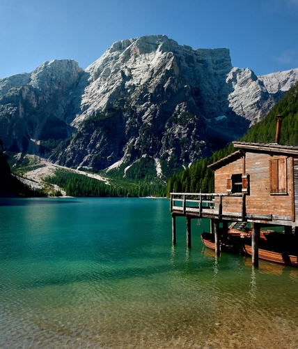 Immagine con lago, montagna, barche, legno, acqua, montagne, verde, alberi, cielo, baita, casa, bosco, roccia, pali, azzurro, braies, palafitte