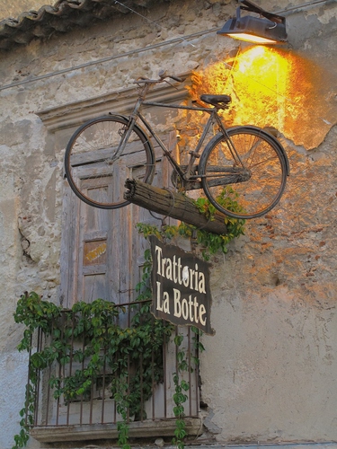 Immagine con bicicletta, insegna, balcone, luce, trattoria, lampione, appesa, rampicante, finestra