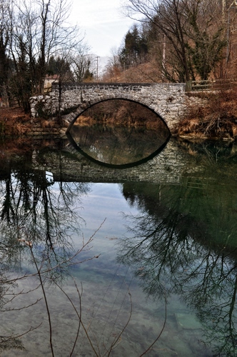 Immagine con ponte, alberi, fiume, riflesso, acqua, cielo, rami, nuvole, arco, riflessi