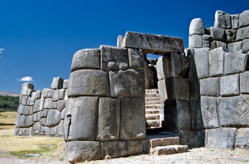 Immagine con porta, pietre, gradini, cielo, ruderi, rovine, massi, scale, archeologia, fortezza, sassi, grigio, nuvole, scala, muro, scalini, blocchi, portale, azzurro, sito, alberi, antichità