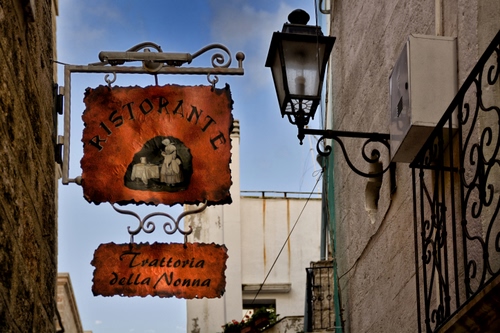 Immagine con lampione, insegna, cielo, ringhiera, balcone, insegne, ristorante, ferro, trattoria, palazzo, muro