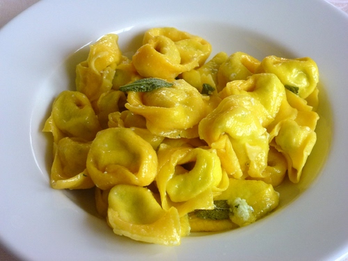 Immagine con piatto, tortellini, giallo, salvia, pasta, cibo, ravioli, verde, bianco, foglie, primo, burro, tortelli