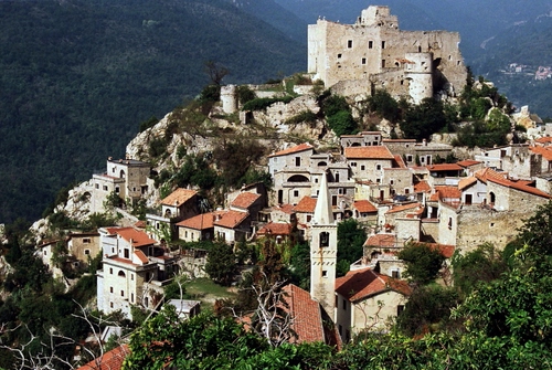Immagine con castello, campanile, borgo, panorama, case, montagna, paese, tetti, torre, alberi