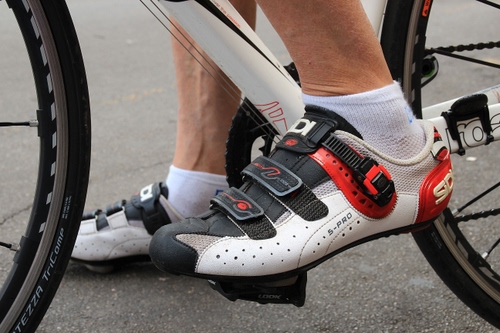 Immagine con ruote, scarpe, bicicletta, bianco, rosso, raggi, ciclista, piedi, pedali, pedale, calze, calzini, piede, caviglie, sport, nero, catena, gambe