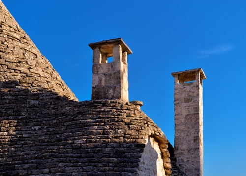 Immagine con cielo, trullo, comignoli, tetto, due, pietre, sassi