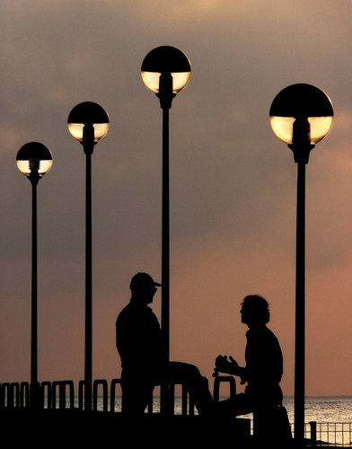 Immagine con lampioni, mare, persone, tramonto, quattro, controluce, due, figure, luci