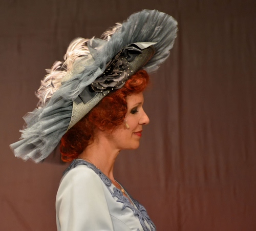 Immagine con cappello, profilo, donna, capelli, rossi, piume, grigio, vestito, naso, bocca, elegante, occhi, viso, ritratto