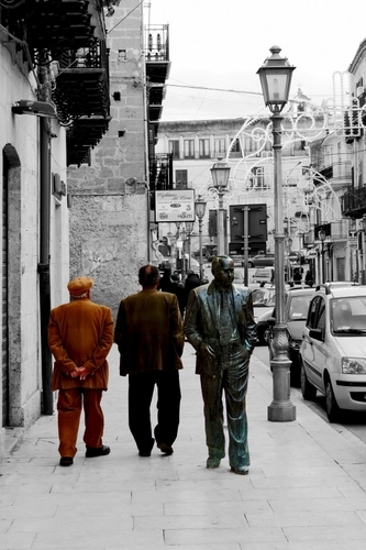 Immagine con statua, lampione, passanti, marciapiede, lampioni, via, uomini, persone, tre, strada, balconi, auto