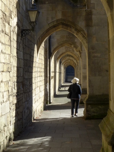 Immagine con archi, donna, lampione, portico, passante, ombre, portici, prospettiva, cappello, persona