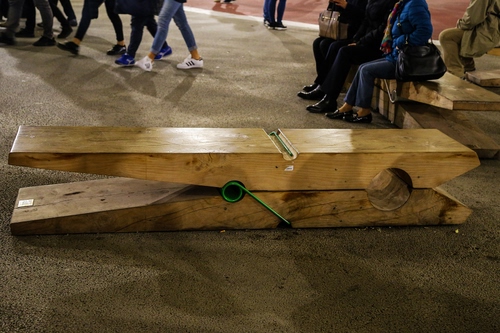 Immagine con molletta, legno, panchina, gambe, panchine, piazza, passanti, persone, strada, mollette