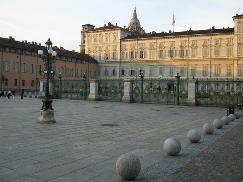 Immagine con bandiera, piazza, lampione, sfere, cupola, palazzo, palazzi, lampioni, finestre, cancellata, palle, campanile, castello, recinzione, ferro, reggia, torino, comignoli, reale, piazzale, persone