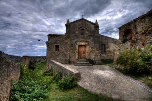 Immagine con chiesa, porta, nuvole, croce, cielo, verde, facciata, finestre, piante, fiori