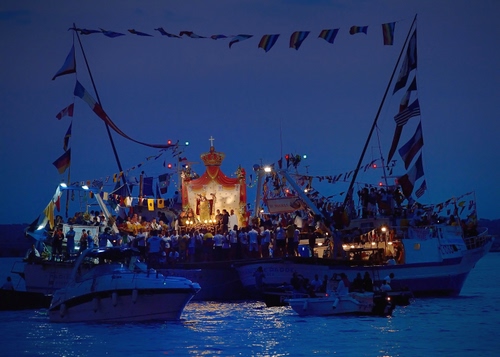 Immagine con barche, mare, bandiere, devozione, processione, blu, luci, notte, croce