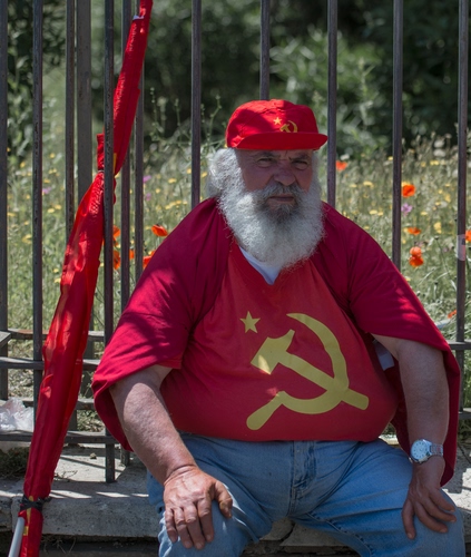 Immagine con rosso, martello, falce, cappello, barba, bandiera, uomo, devozione, berretto, comunista