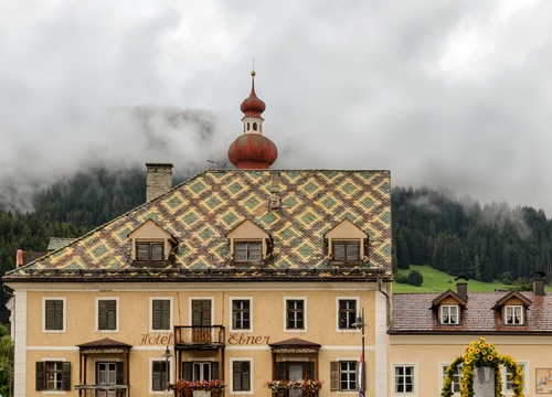 Immagine con tetto, finestre, abbaini, hotel, nuvole, fiori, cupola, alberi, campanile, albergo, balconi, nebbia, camino, tetti, comignolo, palazzo, persiane, bosco, comignoli, balcone