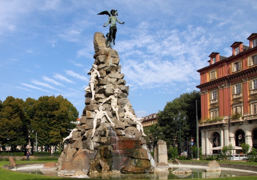 Immagine con fontana, statue, alberi, nuvole, cielo, monumento, palazzo, angelo, acqua, pietre, finestre, ali, verde, abbaini, casa