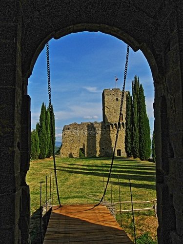 Immagine con castello, alberi, ponte, arco, catene, cielo, verde, levatoio, bandiera, prato, cipressi, fortezza, azzurro, torre, passerella, nuvole, ombre, ingresso, ombra, erba, rudere, cornice