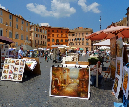 Immagine con piazza, ombrelloni, finestre, quadri, nuvole, mercato, palazzi, case, cielo, mercatino, stampe, azzurro, persone, dipinti, bancarelle, colori, lampioni, esposizione