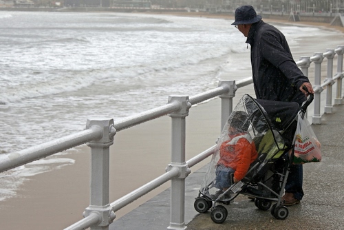 Immagine con mare, passeggino, bambino, spiaggia, ringhiera, pioggia, nonno, uomo