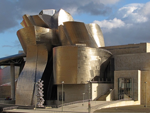 Immagine con nuvole, cielo, architettura, lampioni, edificio, moderno, porta, curve, oro, bilbao, metallo, museo, palazzo, riflessi
