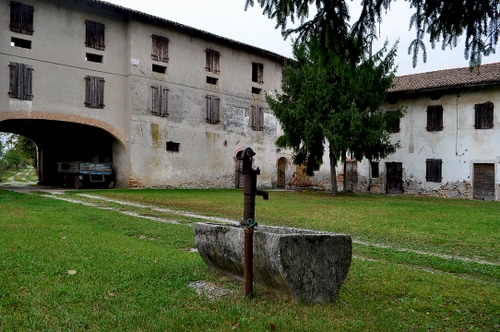 Immagine con finestre, verde, arco, erba, fontana, prato, albero, porte, cascina, portico, vasca, case, rimorchio, pietra, alberi, strada, cortile, pompa, carro, casolare, rami