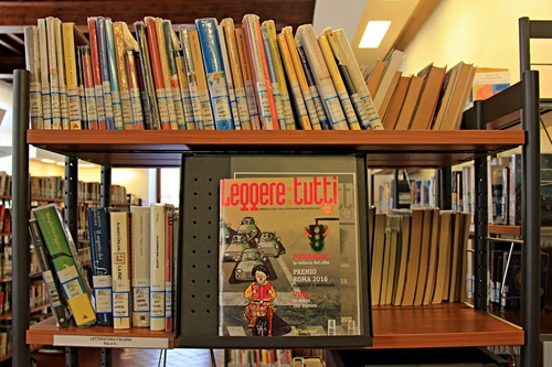 Immagine con libri, biblioteca, scaffali, libreria, scaffale, etichette, ripiani, legno, volumi, titolo, tanti, scritte, copertina