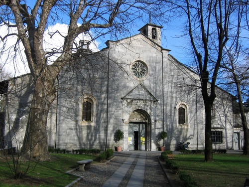 Immagine con chiesa, alberi, panchina, rosone, campanile, strada, finestre, rami