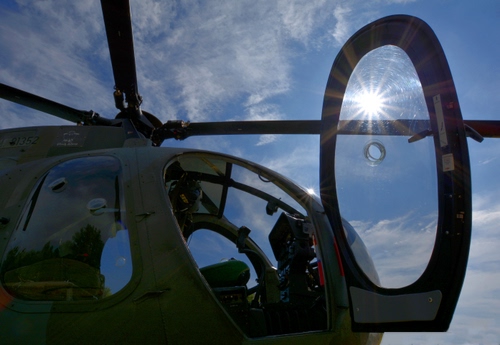 Immagine con cielo, elicottero, sole, nuvole, pale, cabina, sportello, raggi, vetro, azzurro, eliche, portellone, controluce, rotore, vetri