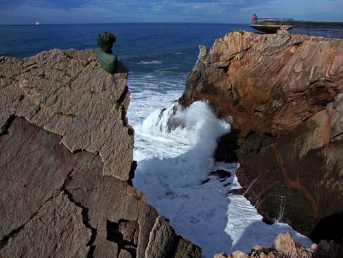 Immagine con mare, onde, scogli, acqua, rocce, scogliera, blu, cielo, schiuma, bianco, roccia, nuvole, orizzonte, nave, statua