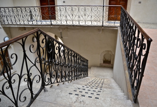 Immagine con porte, scala, ringhiera, gradini, pianerottolo, arco, ferro, corrimano, scalini, balaustra, marmo, bianco, scalinata, inferriata, balcone, interno