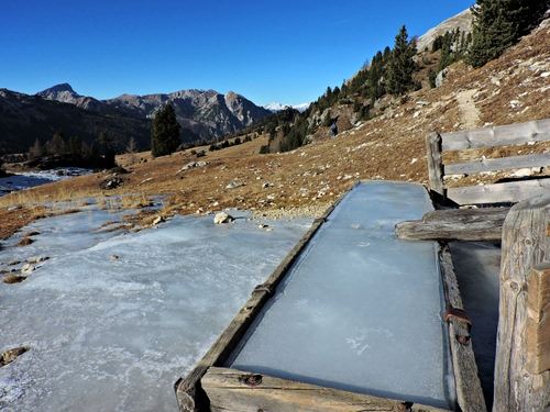 Immagine con ghiaccio, legno, montagna, alberi, fontana, abbeveratoio, staccionata, inverno, acqua, azzurro, cielo, montagne, verde, freddo, lavatoio, vasca