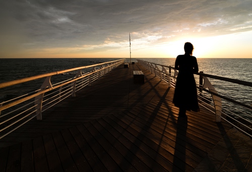 Immagine con mare, ombre, donna, pontile, controluce, cielo, panchine, tramonto, nuvole, orizzonte, persona, asta, ringhiere, alba, molo, luce, acqua, silhouette