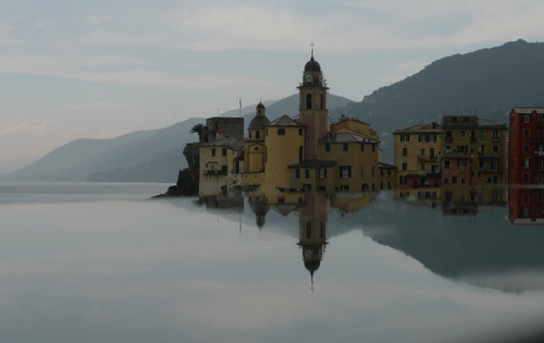 Immagine con campanile, riflesso, acqua, mare, chiesa, case, montagne, borgo, cielo, riflessi