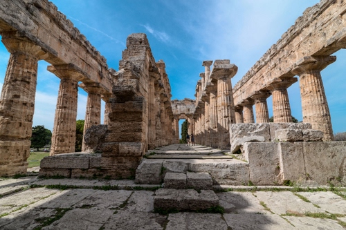 Immagine con colonne, tempio, cielo, pietre, nuvole, ruderi, azzurro, verde, archeologia, alberi, antichità, capitelli, rovine, prospettiva