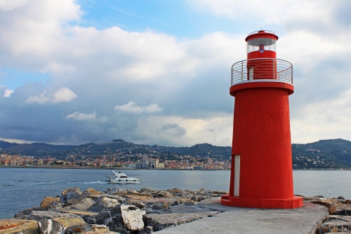 Immagine con mare, faro, rosso, barca, nuvole, cielo, città, scogli, molo, acqua, porta, fanale, colline, sassi, ringhiera, lanterna